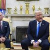 In this photo, President Trump and Jordanian King Abdullah II sit on armchairs at the White House. Both are wearing dark blue suits, and Abdullah II is on the left, while Trump is on the right. A fireplace is behind them.